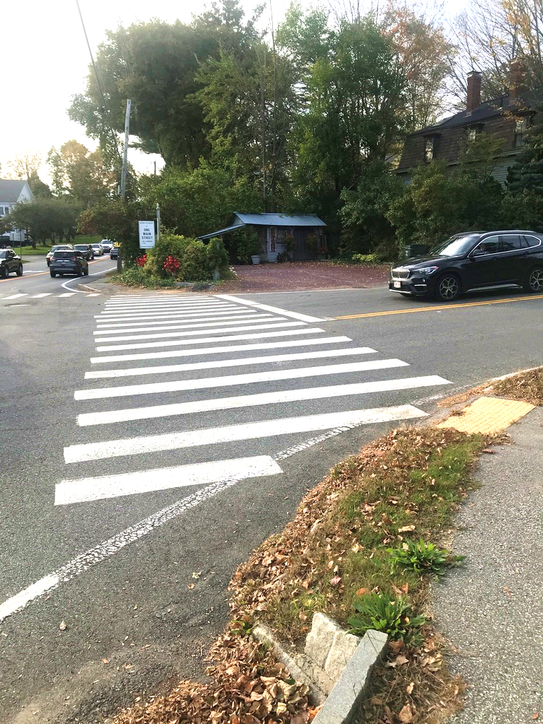 Figure 5 - Pedestrian Facilities for Northeast Intersection Corner’s Library Hill Road Crossing. Image shows a pedestrian detectable warning strip, a sidewalk made of pavement, and a crosswalk.